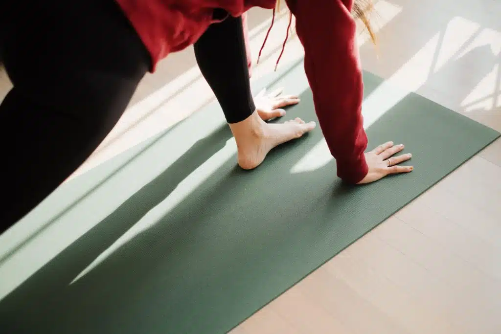 Woman on a yoga mat with her leg mid pilates move