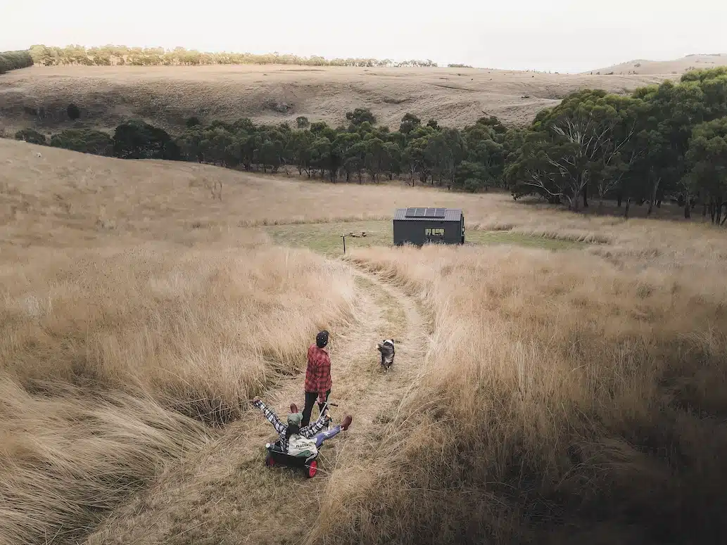 A couple and their dog walking to an Unyoked cabin